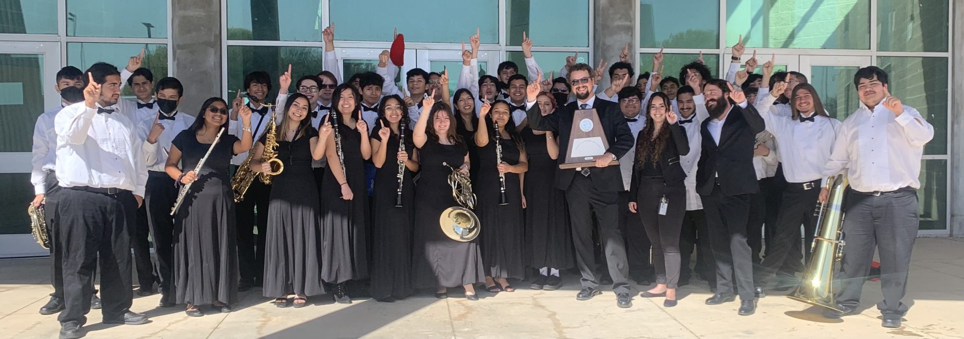 The Southside High School varsity wind ensemble along with Ms. Anna Casillas (asst. director), Mr. Michael Misko (head director), and Mr. Benjamin Swaner (percussion instructor/FA tutor) celebrate their victory. 