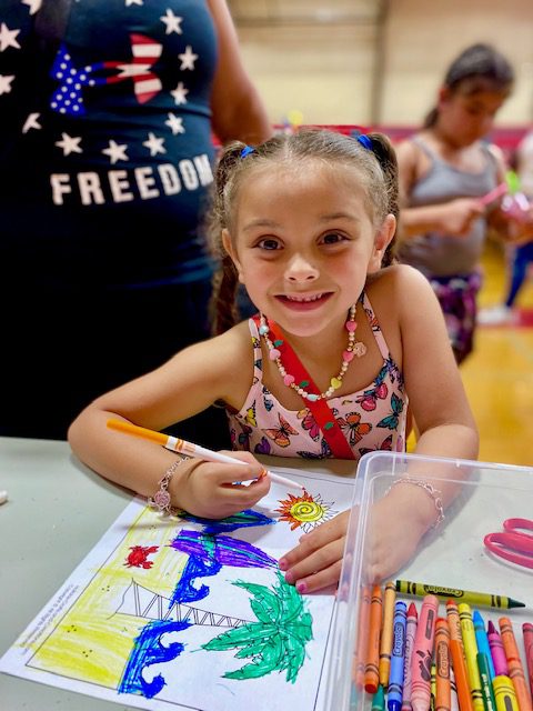 A young student enjoys coloring at the 2022 End of Year Celebration at Southside High School. 