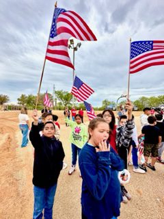 Heritage Elementary students wave American flags during a First Responder's Day ceremony at the campus. 
